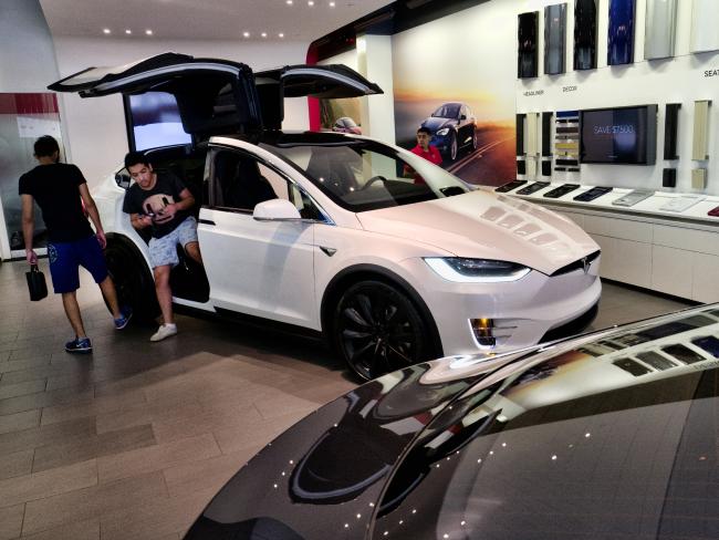 Customers check out the Tesla X, at the Tesla showroom in Santa Monica, California. Picture: AP