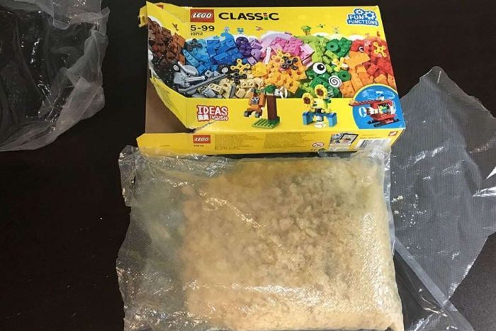 A Lego box and a bag of a light-brown crystal substance.|700x467