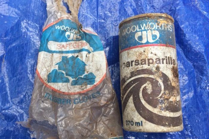 A dirty branded plastic bag and drinking can lie on a blue tarp. |700x467