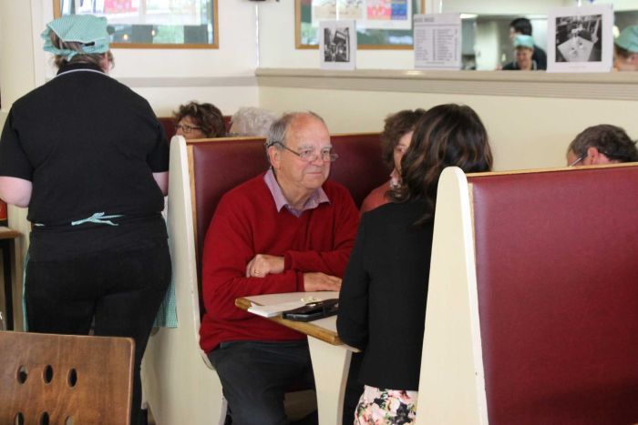 Older people sit in an old-style cafe booth|700x467