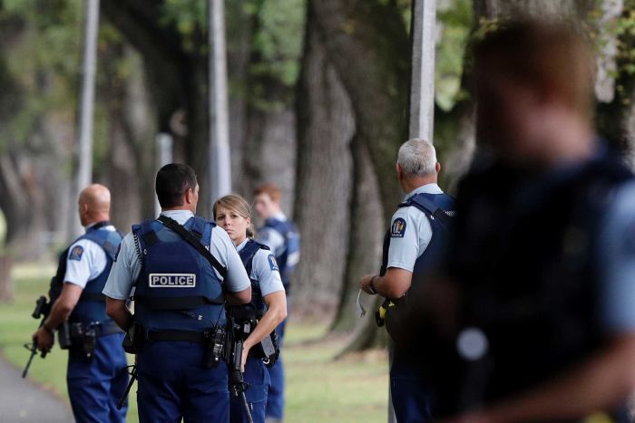 New Zealand police stand in a park after shootings at mosques in Christchurch.|700x467