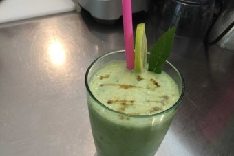 Glass of green blended avocado with straw and mint leaf|340x227